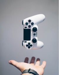 Video game controller floating above hand.